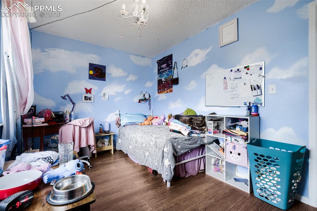 Image 20 of 28: Bedroom featuring wood-finish flooring, white walls, and a large window wit
