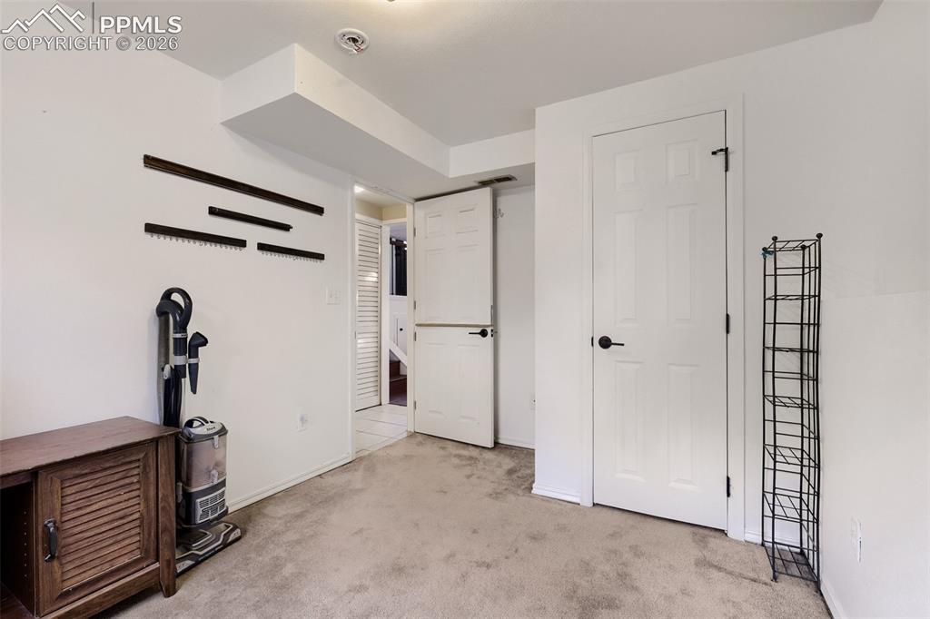 Image 22 of 28: Bedroom featuring wood-finish flooring, white walls, and a window with blin