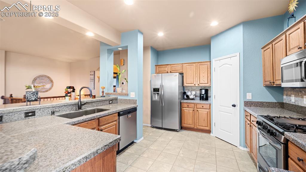 Image 10 of 42: Kitchen with appliances with stainless steel finishes, recessed lighting, d