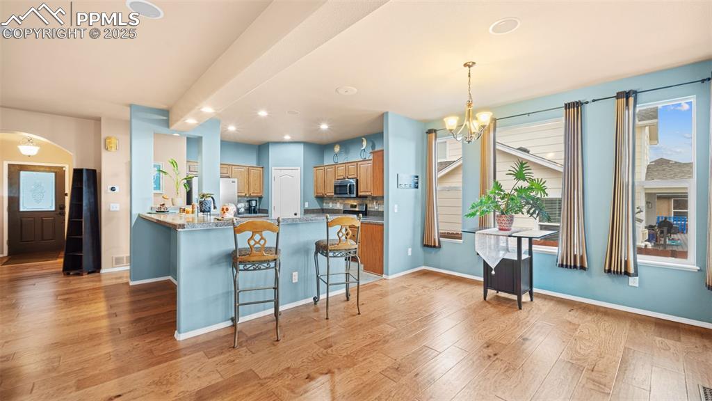 Image 14 of 42: Kitchen with a breakfast bar, a chandelier, recessed lighting, pendant ligh