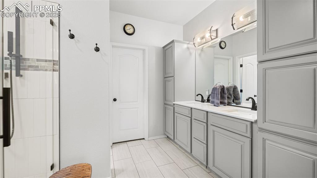 Image 21 of 42: Full bath featuring double vanity and a shower stall