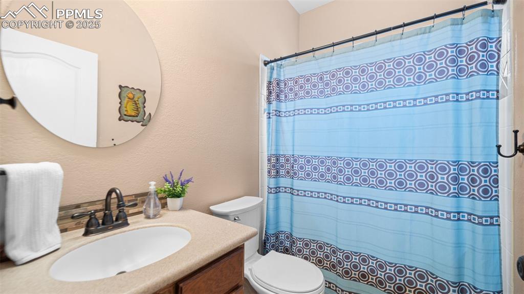 Image 25 of 42: Bathroom featuring vanity, a shower with shower curtain, and a textured wal