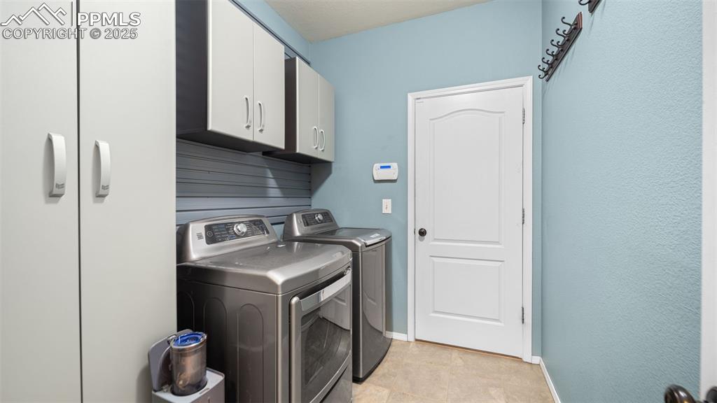 Image 26 of 42: Laundry room featuring cabinet space and washer and dryer
