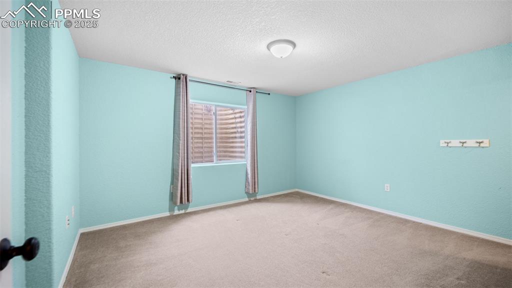 Image 30 of 42: Carpeted bedroom with a textured ceiling and baseboards