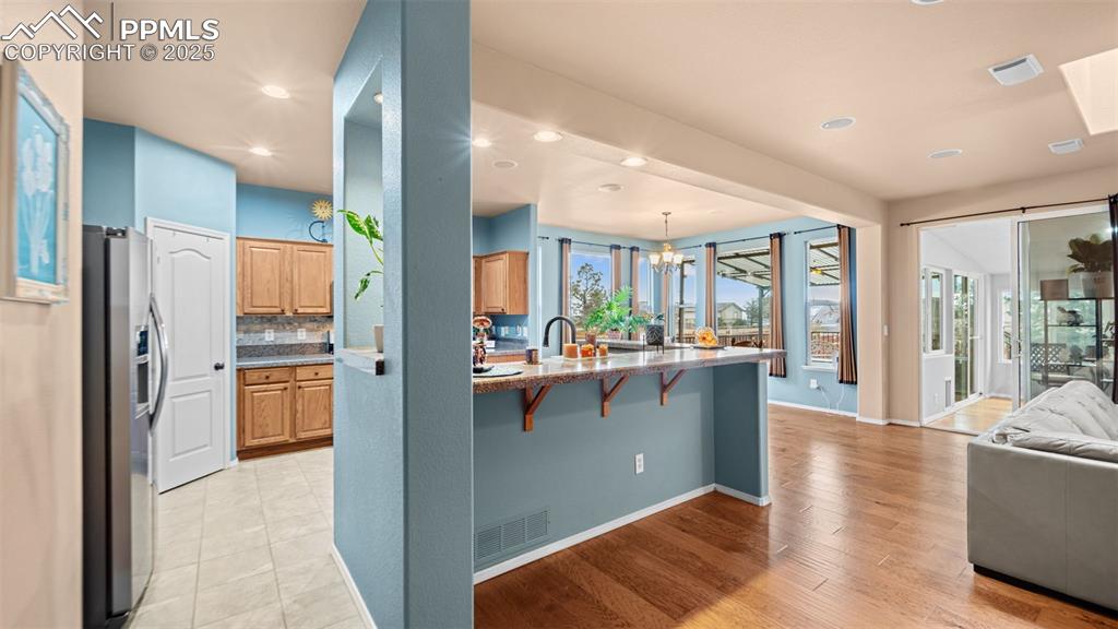 Image 9 of 42: Kitchen with a kitchen breakfast bar, stainless steel fridge with ice dispe