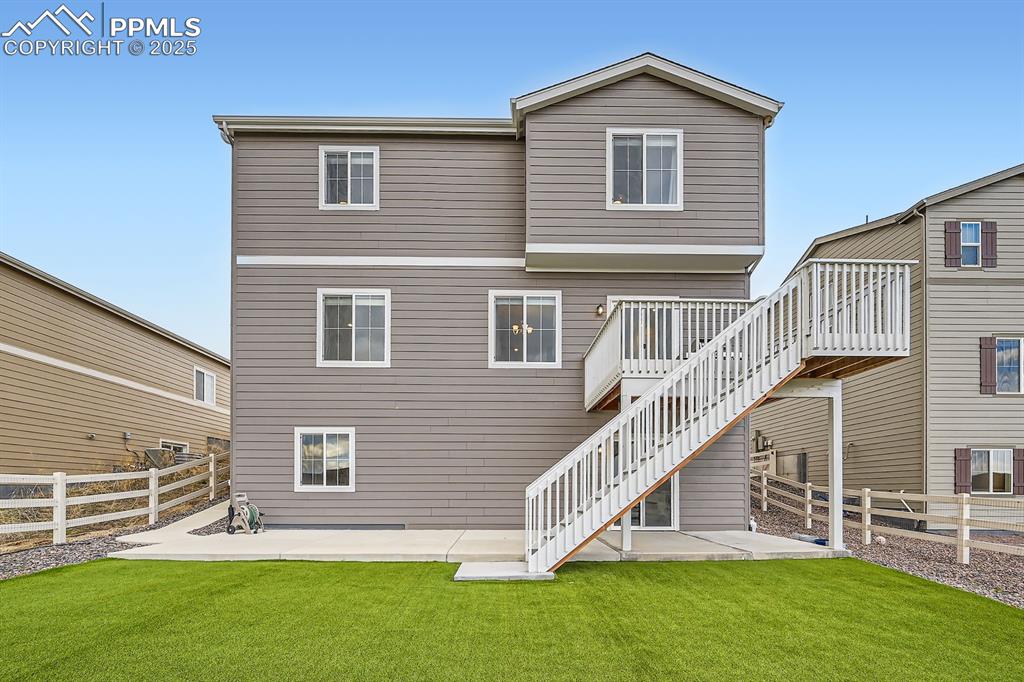 Image 36 of 48: Back of property featuring a lawn, stairs, a patio, and a fenced backyard