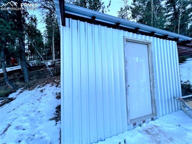 Image 10 of 21: Snow covered structure featuring a storage shed