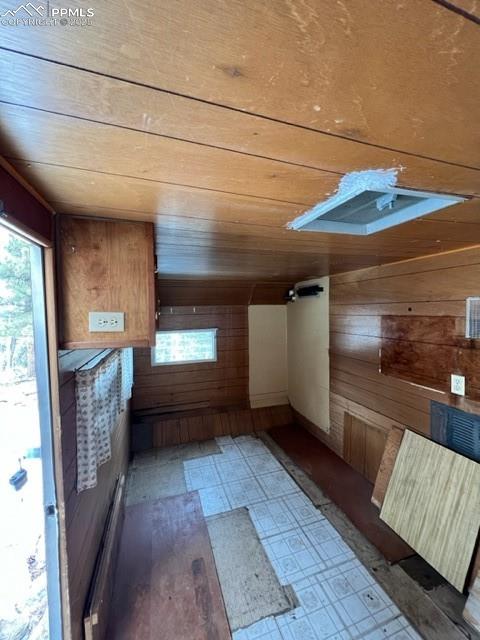 Image 18 of 21: Bonus room featuring wooden walls and light floors