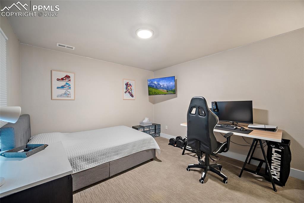 Image 22 of 45: Bedroom with a desk and carpet