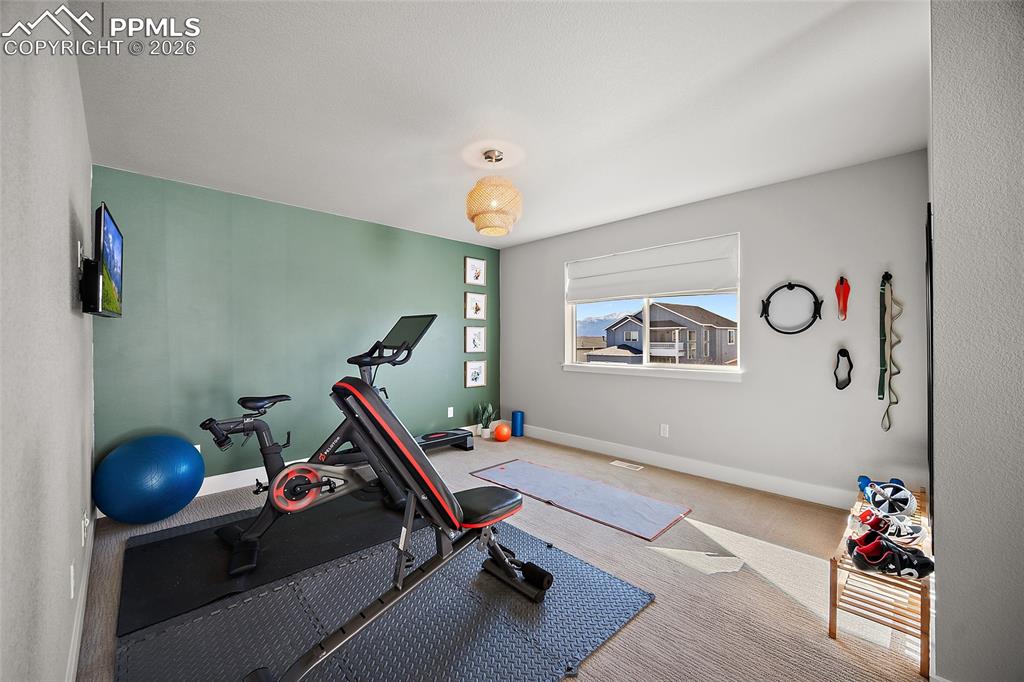 Image 27 of 45: Workout room with baseboards and carpet floors