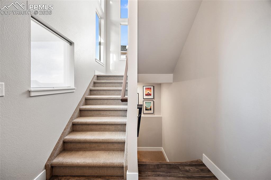 Image 5 of 45: Stairs featuring baseboards and wood finished floors