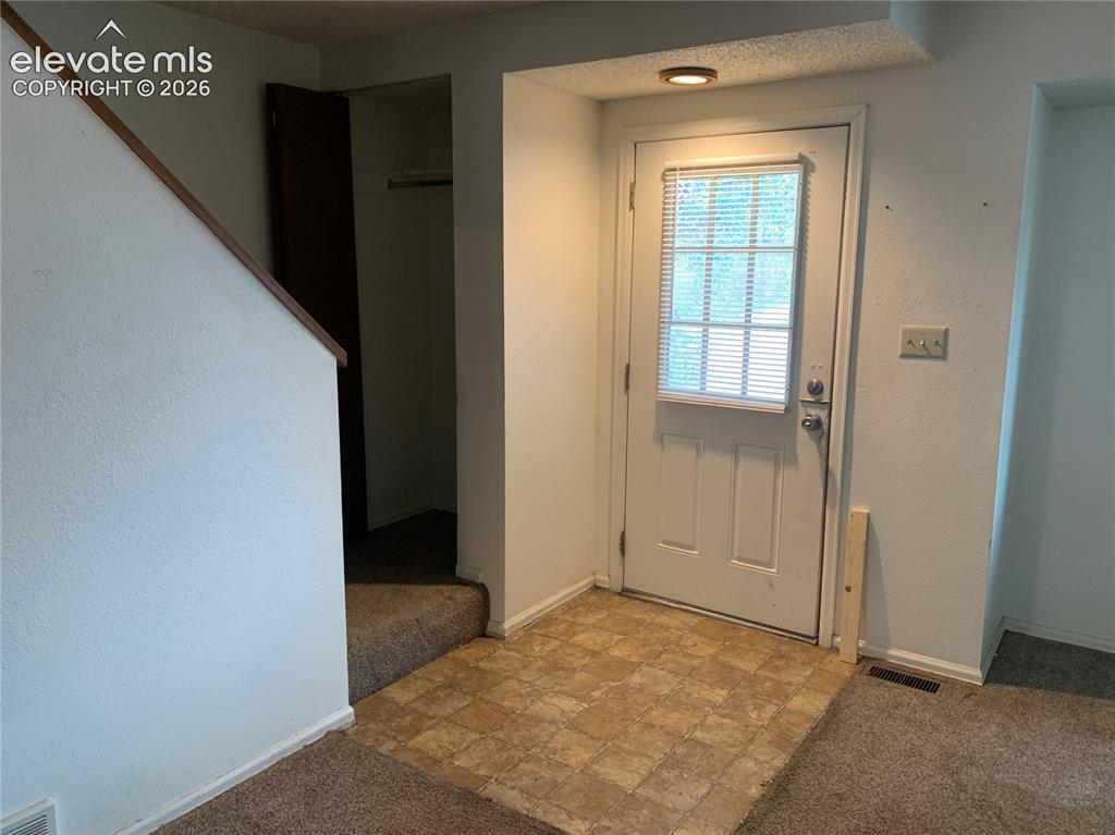 Image 10 of 27: Entryway featuring a paneled door with window blinds, flush-mount lighting,