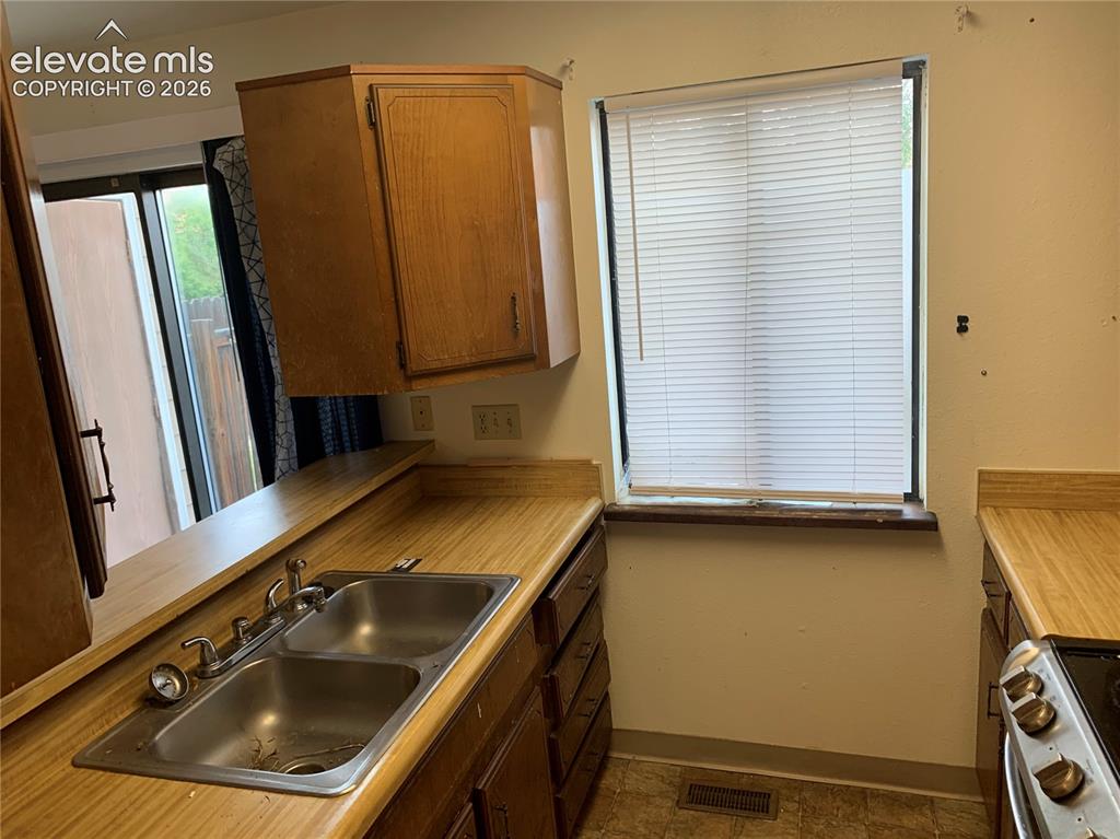 Image 12 of 27: Kitchen featuring wood-finish countertops, stainless steel double-basin sin