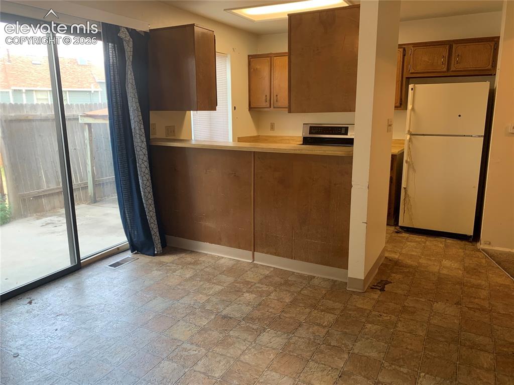 Image 15 of 27: Kitchen with built-in cabinetry, an integrated cooktop, and a double-door r