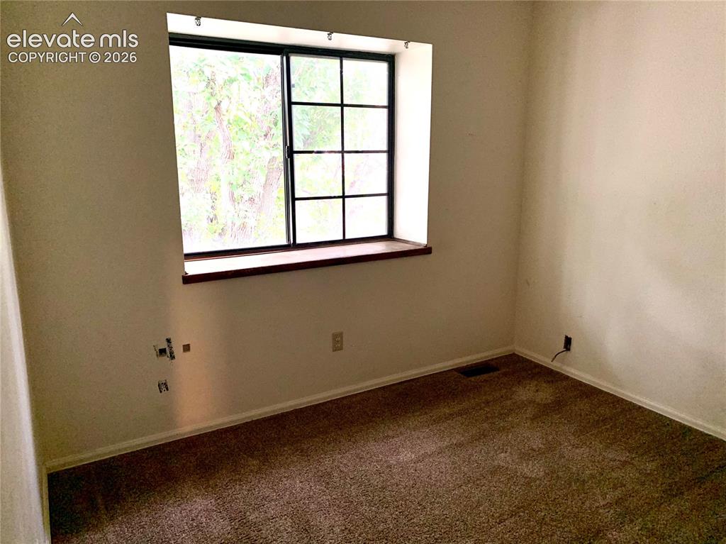 Image 15 of 18: Window with dark frames, wood-finish window sill, and carpeted flooring