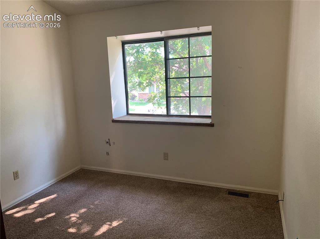 Image 22 of 27: Carpeted room featuring a large window with grid panes and a wood window si