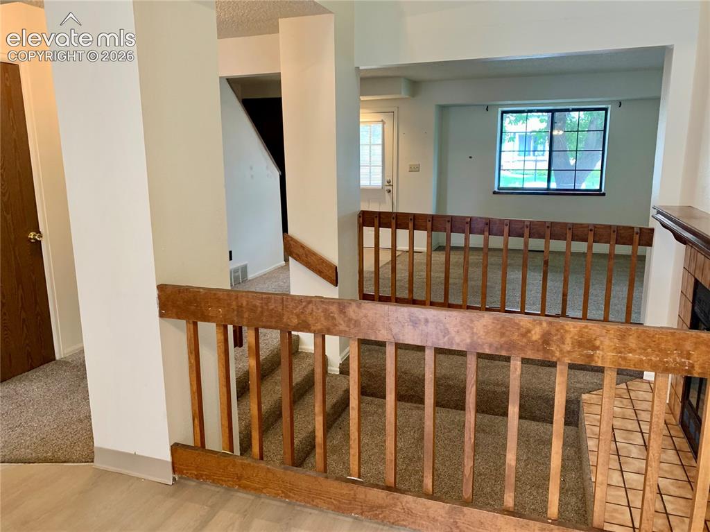 Image 9 of 18: Dining room with view into living room areas featuring wood-finish railings