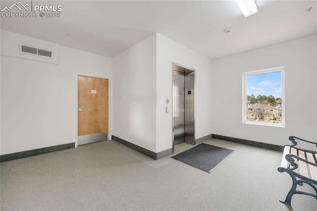 Image 37 of 42: Central elevator with wide hallways and doors.