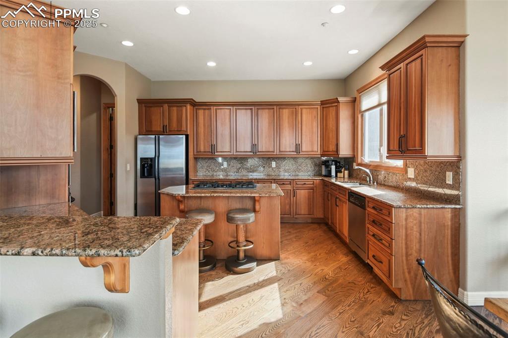 Image 11 of 39: Kitchen featuring a kitchen breakfast bar, light wood-style floors, applian