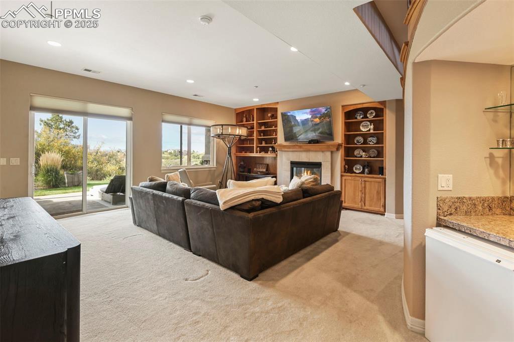 Image 22 of 39: Living room featuring a fireplace, built in features, light colored carpet,
