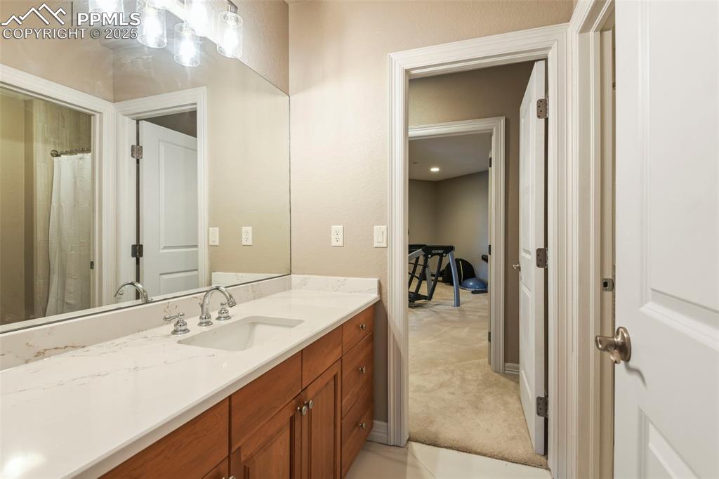 Image 25 of 39: Bathroom with vanity, light carpet, and a shower with curtain