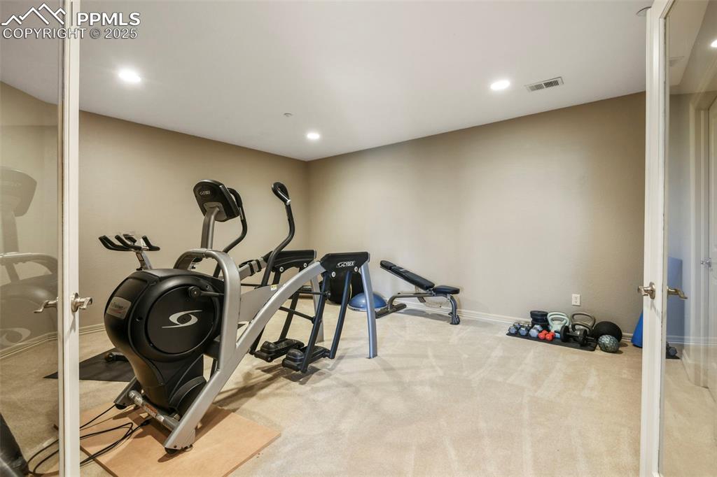 Image 26 of 39: Workout room with light colored carpet and recessed lighting