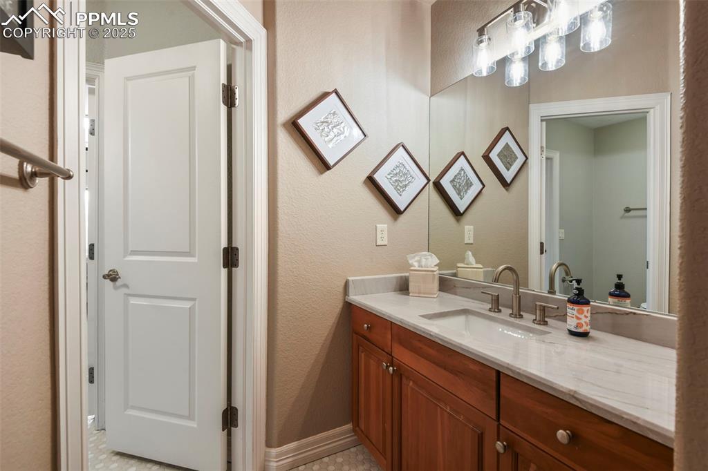Image 31 of 39: Bathroom with vanity and a textured wall