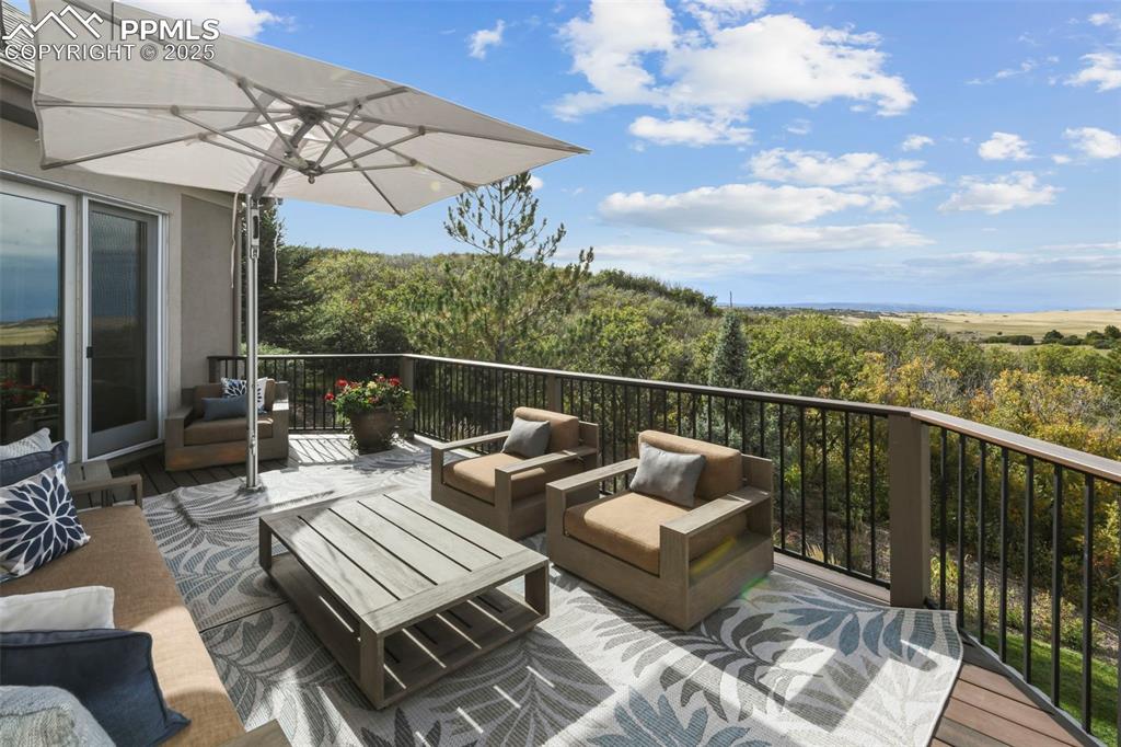Image 34 of 39: Wooden terrace with an outdoor living space and a patio
