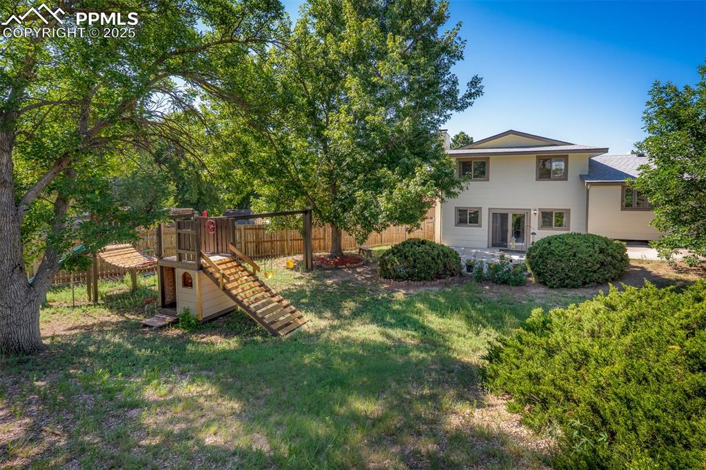 Image 12 of 49: playset and patio.