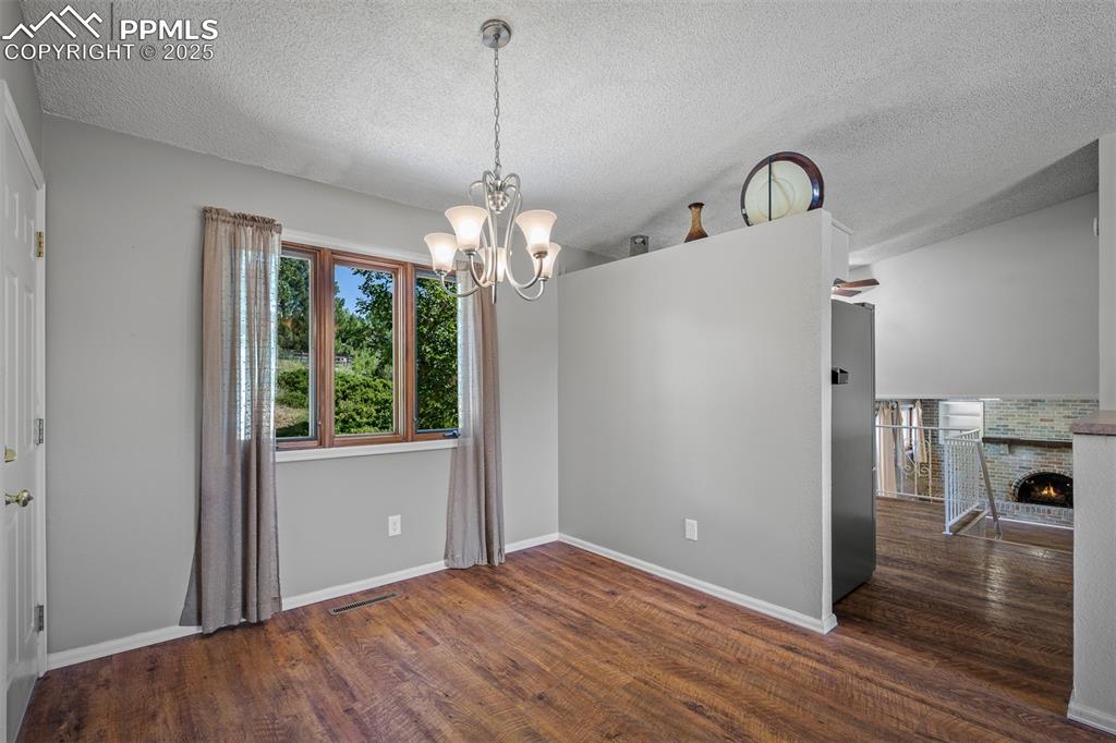 Image 22 of 49: View from main level dinning area looking into warm fireplace family room o