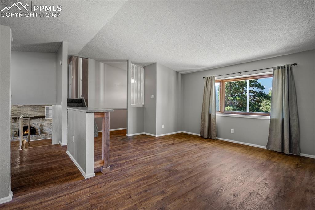 Image 24 of 49: Entry way, living room and view of lower level fireplace.