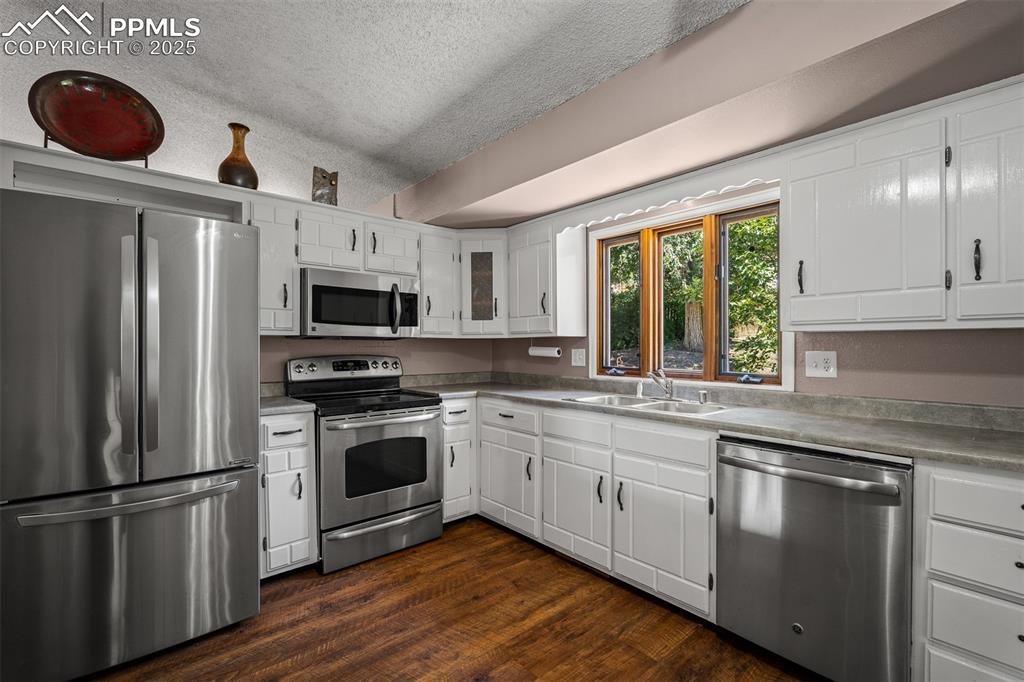 Image 28 of 49: White cabinets, stainless steel appliances. Lots of room to prepare wonder