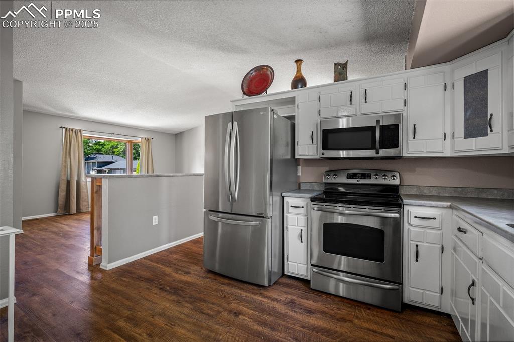 Image 29 of 49: Kitchen with living room in background.