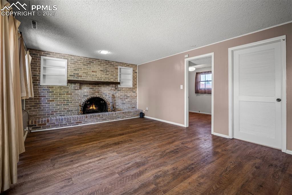 Image 32 of 49: Family room peaking into lower level bedroom with full bath. Laundry room