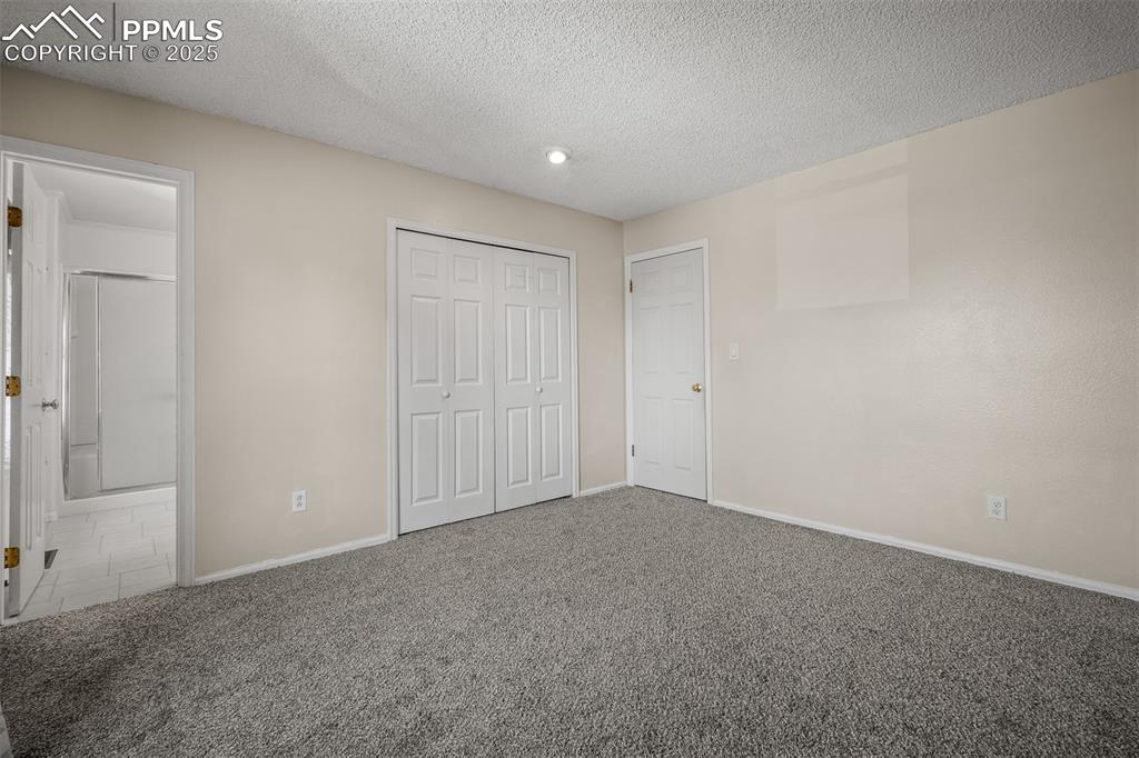 Image 39 of 49: Primary bedroom with bathroom and new carpet.