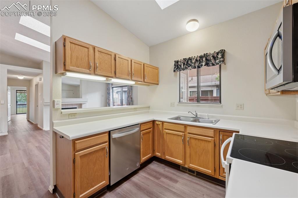 Image 10 of 27: A third skylight bathes the kitchen in lots of natural light