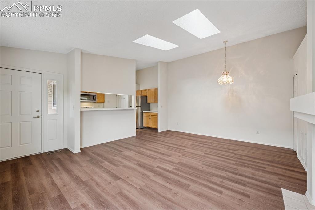 Image 6 of 27: The unit features an open floor plan between the living, dining, and kitche