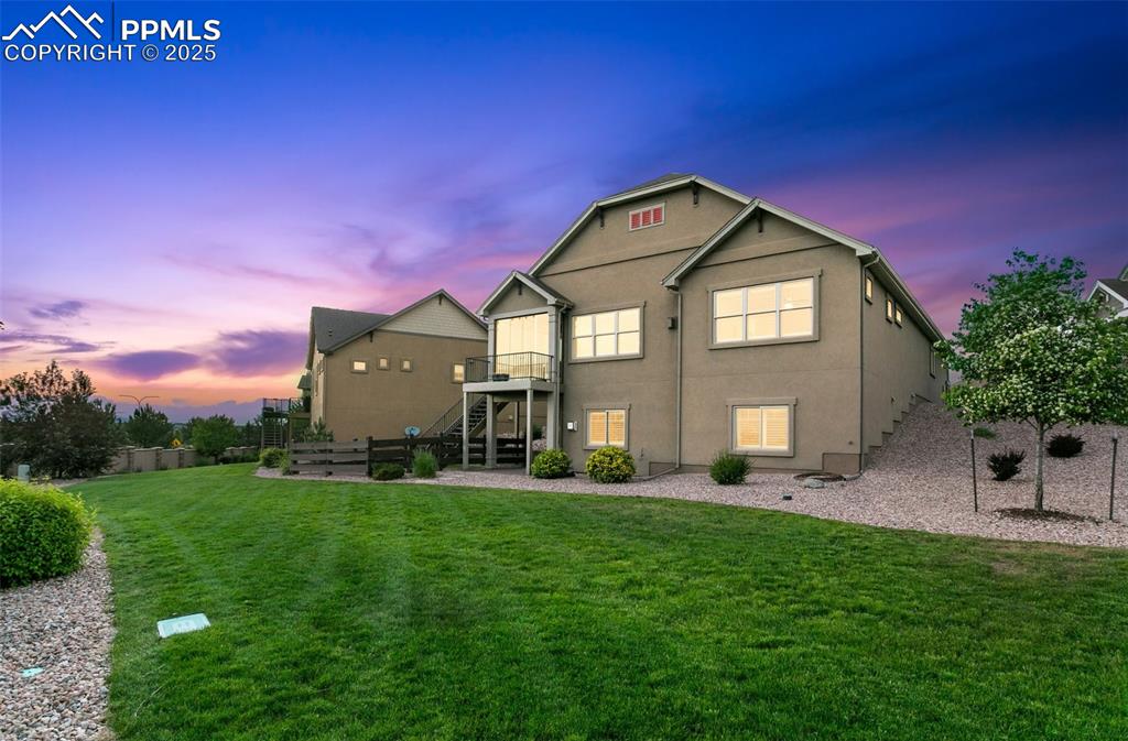 Image 38 of 50: Rear view of property with stairs, a yard, a wooden deck, and stucco siding