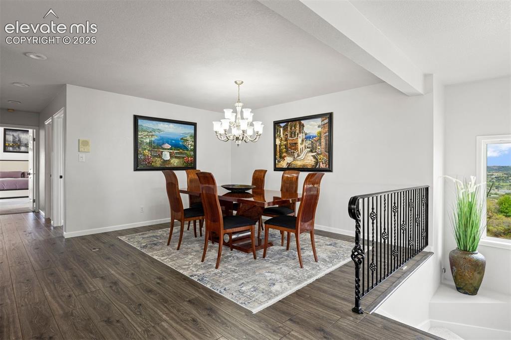 Image 12 of 38: Upper level landing with ornate black wrought iron open banister, crystal c