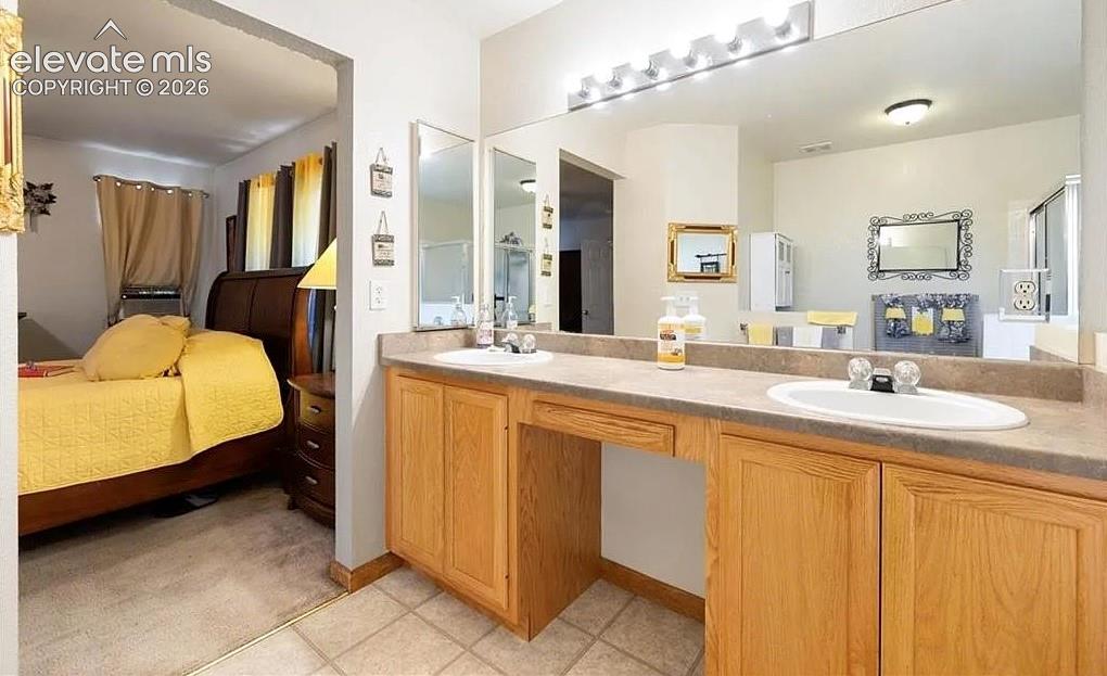 Image 12 of 20: Bathroom vanity featuring dual sinks with built-in cabinetry, a laminate co