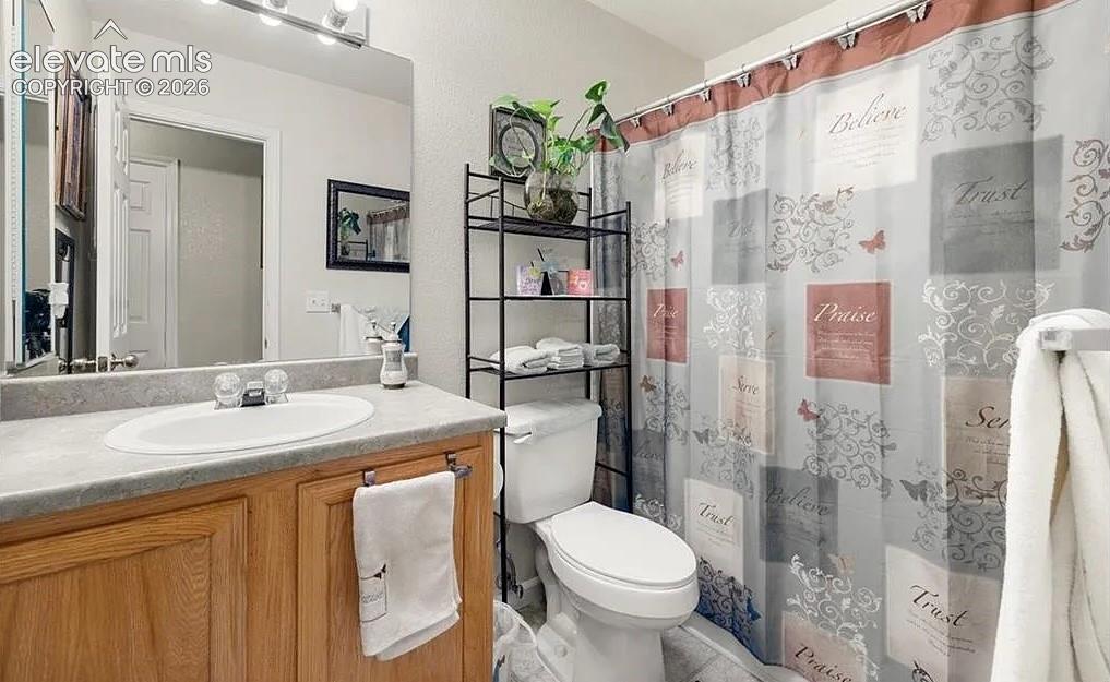 Image 15 of 20: Bathroom featuring a wood-finish vanity with a laminate countertop and inte