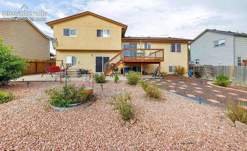 Image 20 of 20: Multi-level stucco exterior with an upper-level wood deck and a lower-level