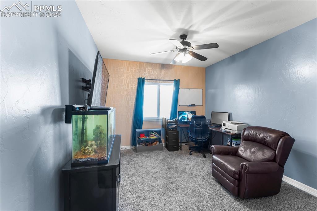 Image 10 of 48: Main Level Bedroom/Office with a textured wall, carpet flooring, and ceilin