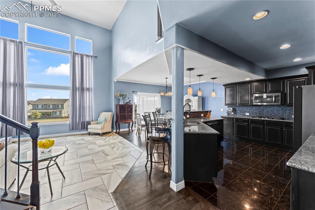 Image 13 of 48: Main Level Kitchen with a kitchen bar, tasteful backsplash, dark cabinetry,