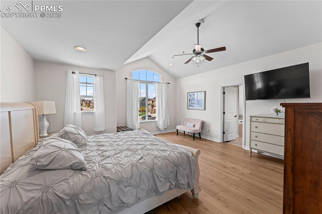 Image 20 of 48: Primary Bedroom with vaulted ceiling, light wood finished floors, ceiling f