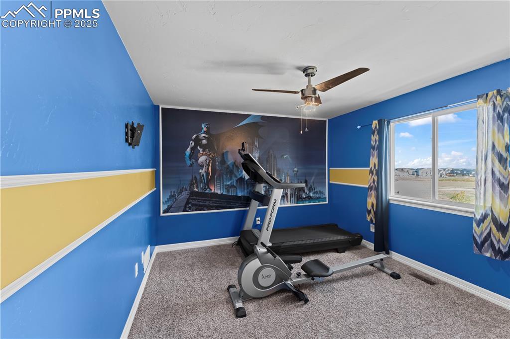 Image 26 of 48: Upstairs bedroom/ Exercise area with a ceiling fan and carpet flooring