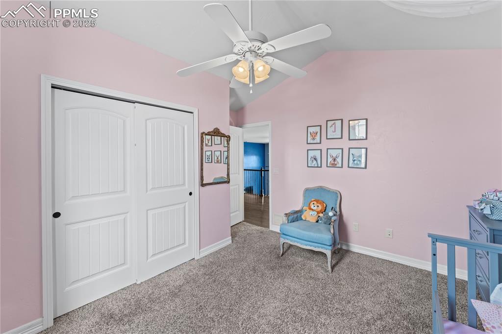 Image 29 of 48: Upstairs Carpeted bedroom featuring lofted ceiling, a ceiling fan, and a cl