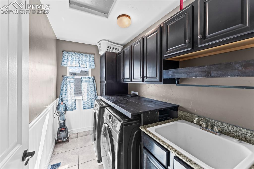 Image 31 of 48: Upstairs Washroom with light tile patterned floors, washing machine and clo