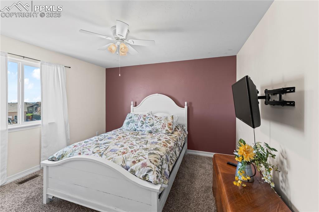 Image 32 of 48: Upstairs Bedroom with a ceiling fan and carpet flooring