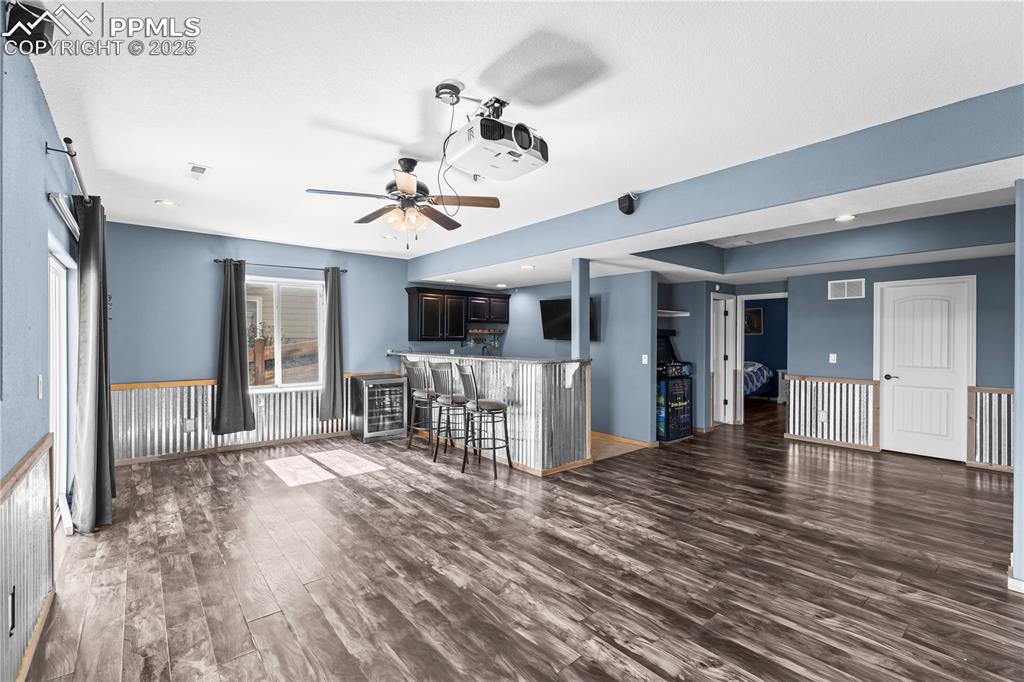 Image 37 of 48: Basement Family/Living area featuring dark wood-style flooring, bar, recess